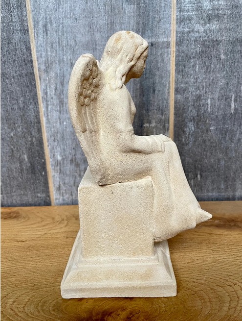 Kleine Merle sitzend auf Sockel