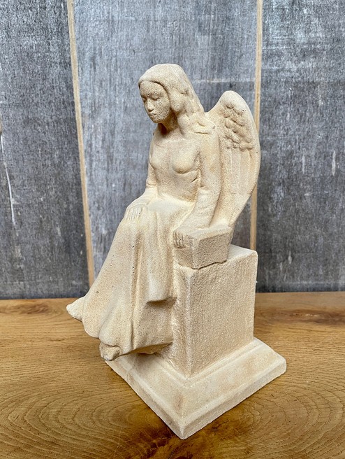 Kleine Merle sitzend auf Sockel